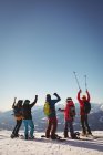 Vista posteriore per celebrare gli sciatori in piedi sulle montagne innevate — Foto stock