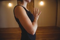 Обрізаний вид жінки, що практикує йогу в фітнес-студії — стокове фото