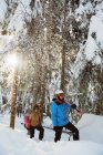 Casal com esqui e snowboard andando na encosta da montanha nevada — Fotografia de Stock