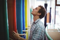 Uomo guardando tavole da surf colorate in negozio — Foto stock