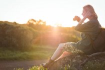 Женщина фотографирует цифровым фотоаппаратом в солнечный день — стоковое фото
