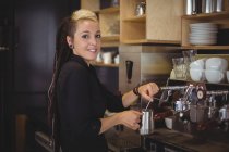 Портрет усміхнений офіціантка, використовуючи кавовий автомат в кафе — стокове фото
