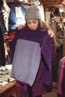 Frau sucht Kleidung in Kleidergeschäft aus — Stockfoto
