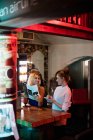 Garçonete discutindo o menu com o cliente no bar — Fotografia de Stock