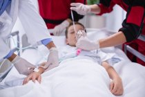 Médicos ajustando a máscara de oxigênio enquanto apressam o paciente na sala de emergência do hospital — Fotografia de Stock