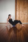 Femme adulte moyenne faisant de l'exercice sur le ballon d'exercice dans un studio de fitness — Photo de stock