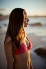 Femme réfléchie debout sur la plage au crépuscule — Photo de stock