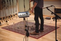 Baixa seção de homem de pé no estúdio de música — Fotografia de Stock