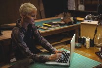 Reife Handwerkerin nutzt Laptop in Werkstatt — Stockfoto