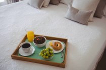 Breakfast tray on bed in bedroom at home — Stock Photo