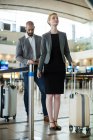 Empresários esperando na fila em um balcão de check-in com bagagem no terminal do aeroporto — Fotografia de Stock