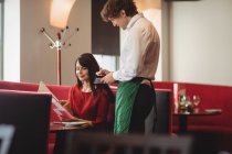 Garçom tomando ordem de mulher em um restaurante — Fotografia de Stock