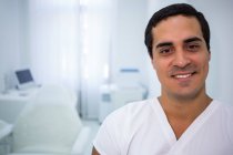 Retrato de sorrir médico masculino em pé na clínica — Fotografia de Stock