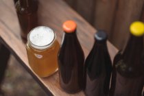 Primo piano di bottiglie di birra fatte in casa e una tazza di birra in un birrificio di casa — Foto stock