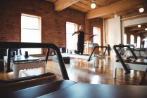 Sportgeräte und Frau üben Pilates auf Reformer im Fitnessstudio — Stockfoto