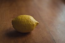 Close-up of a lemon on wooden table — Stock Photo