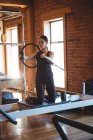 Mulher praticando pilates em reformador usando anel de exercício no estúdio de fitness — Fotografia de Stock