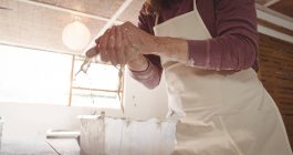 Homme potier lavage des mains après avoir travaillé sur la roue de poterie en atelier de poterie — Photo de stock