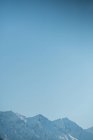 Вид на сніговий гірський хребет на блакитне небо — стокове фото