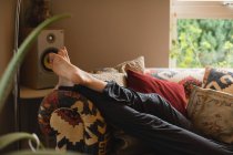 Женщина лежит на диване в гостиной на дому — стоковое фото