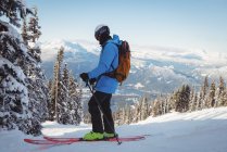 Esquiador esquiando en montañas cubiertas de nieve - foto de stock