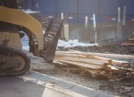 Bulldozer descarregamento de madeira no canteiro de obras — Fotografia de Stock