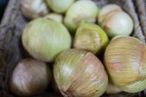 Close-up of fresh onions in wicker basket — Stock Photo