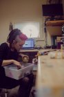 Женщина-парикмахер работает за столом в магазине дредов — стоковое фото