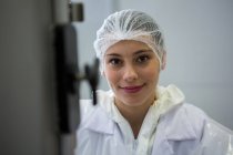Retrato de una carnicera sonriendo en la fábrica de carne - foto de stock