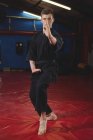 Giovane giocatore di karate adulto che esegue una posizione di karate in palestra — Foto stock