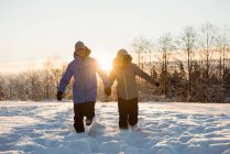 Glückliches Paar spaziert durch verschneite Landschaft — Stockfoto