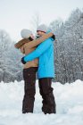 Feliz pareja de esquiadores abrazándose en la montaña nevada - foto de stock