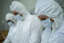 Primo piano dei macellai che indossano maschere in fabbrica di carne — Foto stock