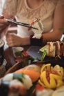 Середина жінки, що має суші в ресторані — стокове фото