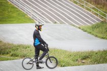 Ciclista de pie con bicicleta BMX en skatepark - foto de stock