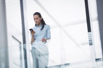 Geschäftsfrau benutzte Handy im Bürogebäude — Stockfoto