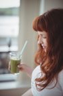 Thoughtful pregnant woman holding glass of juice at home — Stock Photo
