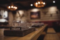 Primo piano del vassoio in legno con bicchieri sul bancone del bar — Foto stock