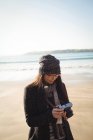 Frau schaut sich tagsüber Fotos mit Digitalkamera am Strand an — Stockfoto
