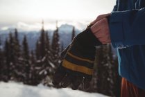 Midsection of man wearing gloves at mountain during winter — Stock Photo