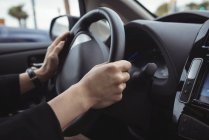 Hands of man driving electric car — Stock Photo