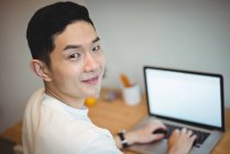 Portrait d'un dirigeant d'entreprise souriant travaillant sur un ordinateur portable au bureau — Photo de stock