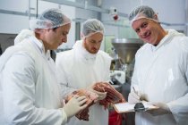Metzger halten in Fleischfabrik Platten auf Klemmbrett — Stockfoto