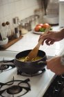 Mãos de homem preparando macarrão na cozinha em casa — Fotografia de Stock