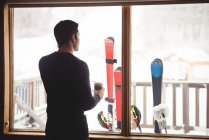 Человек перед окном в лыжном домике — стоковое фото