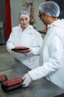 Carniceros envasan carne picada en fábrica de carne - foto de stock
