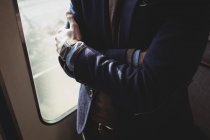 Milieu de l'homme d'affaires debout avec les bras croisés dans le train — Photo de stock
