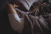 Мужчина спит в постели в спальне дома — стоковое фото