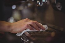 Primer plano de la camarera limpiando la máquina de café espresso con servilleta en la cafetería - foto de stock