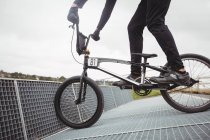 Cyclist preparing for BMX racing at starting ramp in skatepark — Stock Photo